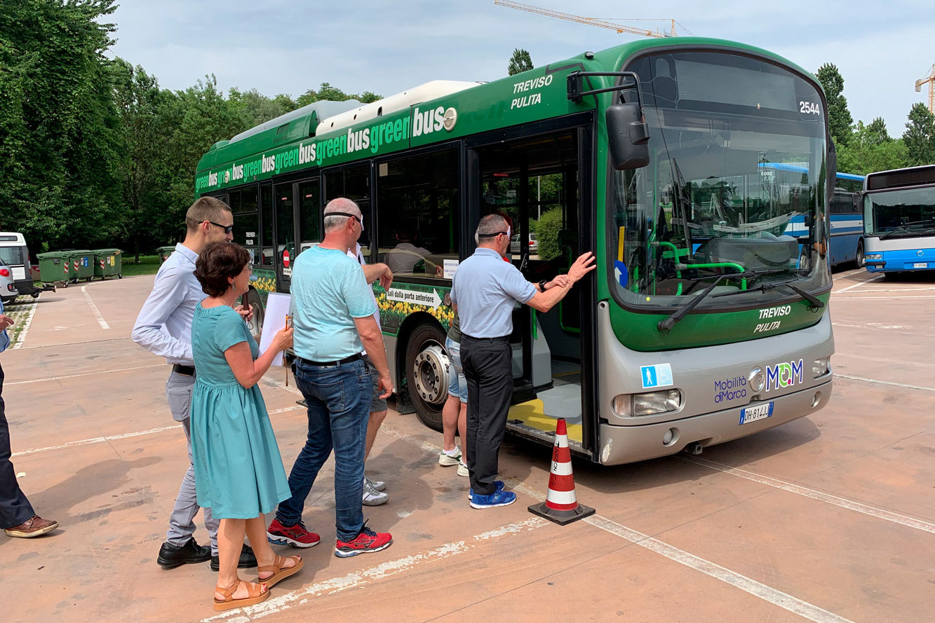 Un gruppo di autisti di autobus dell'azienda MOM simulano la salita sul mezzo indossando delle bende sugli occhi